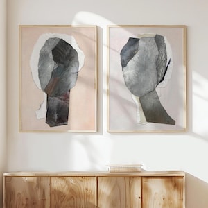 Könnte beinhalten: Zwei gerahmte abstrakte Kunstdrucke mit rosa Hintergrund und grau-weißen Papierkollagen.