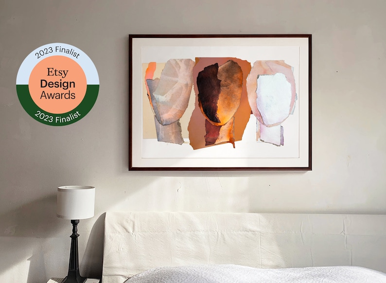 A 2023 Etsy Design Award finalist original art print on a wall in a white bedroom. The tree abstract heads are in grayish to brown orange, in intense dark wood to pale pinky orange and marble white with violet. Modern artwork in dark brown frame.