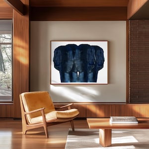 Puede incluir: Una pintura abstracta azul de tres caras, enmarcada y colgada en una pared blanca en una sala de estar moderna con suelo de madera y un sill&oacute;n de cuero marr&oacute;n.