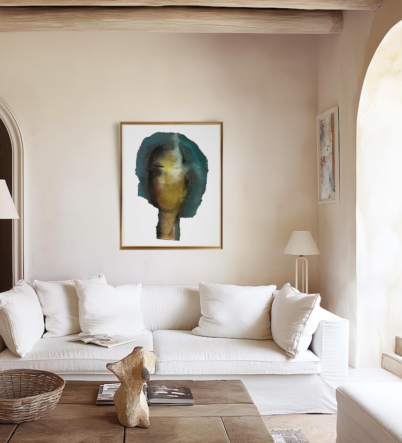 A tie-a room-together high quality light framed art print of a big sized abstract room-tying female portrait in shades of petrol blue, golden, yellow and black. The torn-to-shape laid paper piece has rough edges. The grainy texture is spray painted.