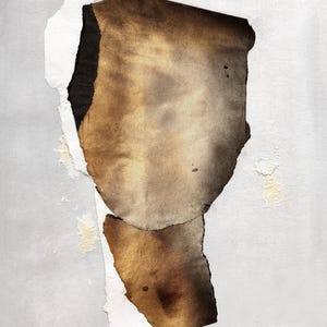 May include: A piece of paper with torn edges, revealing a layer of brown paper underneath. The brown paper has a faded, aged look and is stained with brown and black spots.