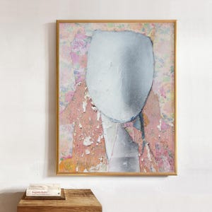 May include: A framed abstract painting featuring a large, central, textured light gray oval shape layered over a background of torn, multi-layered paper in shades of pink, peach, and white with subtle floral patterns and visible paper edges.