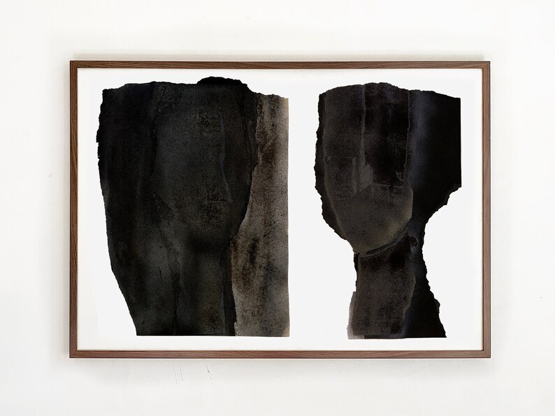 A dark wood framed, high quality art print of a modern abstract double portrait in asphalt black and dark brown on white, composed of a torn paper layers with grungy edges. The texture has a water color effect. Shades of tan browns remind of a nose.