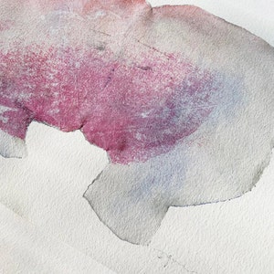 A detail of an art print of an abstract portrait of a kiss in off white, coral and lavender blush pink and pastel violet on white background. It's composed of one torn paper layer with rough edges, accented with fine spray-painted bluish mist.
