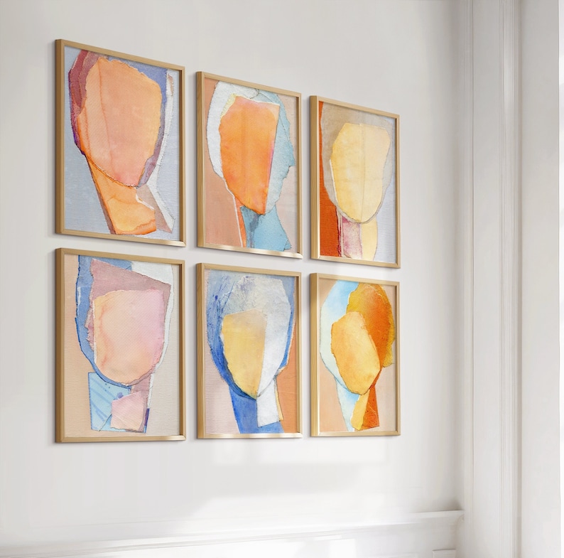 May include: Six abstract art prints in gold frames, each featuring a different color combination of pink, blue, yellow, and orange. The prints are arranged in a grid pattern on a white wall.