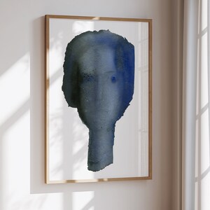 Puede incluir: Pintura abstracta de acuarela de una cara en tonos de azul y gris. La cara est&aacute; delineada en un color azul oscuro y tiene un toque de ojo azul.
