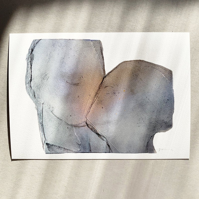 A high quality art print of a romantic abstract portrait of a love couple kiss in greige, dovetail and silver grey on white. The torn paper layers with grungy edges give the fine texture a mural feel. The kiss is accented with a hue of a golden glow.