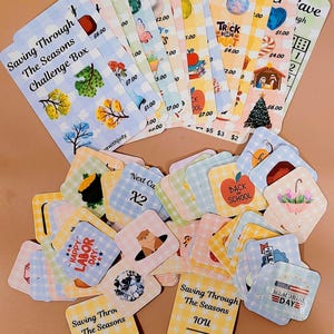 May include: A selection of patterned cards with seasonal designs. The cards display illustrations of leaves, apples, and holiday themes, alongside text including "Saving Through The Seasons Challenge Box" and "Back to School."