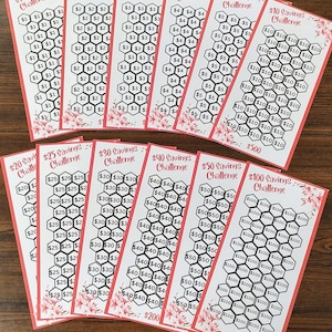 May include: A set of 10 printable savings challenge cards. The cards are printed on white paper with a red border and feature a honeycomb pattern. Each card has a different savings goal amount, ranging from $1 to $100. The cards are labeled with the savings goal amount and the word 'Challenge'. The cards are arranged in a semi-circle on a wooden surface.