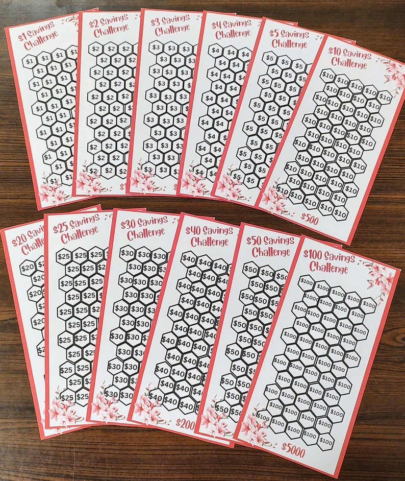 May include: A set of 10 printable savings challenge cards. The cards are printed on white paper with a red border and feature a honeycomb pattern. Each card has a different savings goal amount, ranging from $1 to $100. The cards are labeled with the savings goal amount and the word 'Challenge'. The cards are arranged in a semi-circle on a wooden surface.