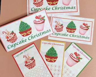 May include: Five printable Christmas cupcake themed cards. The cards feature illustrations of cupcakes with Christmas decorations. The cards have the text "Cupcake Christmas" on them. Two of the cards are blank and two of the cards have a grid of circles for a game.