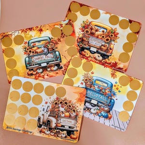 May include: Four rectangular cards with a fall theme. Each card features a truck filled with pumpkins and sunflowers. The cards have gold scratch-off circles and text that reads "COUNTRY FALL", "AUTUMN MOO-MENTS", "HELLO FALL", and "GIVE THANKS".