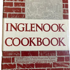 May include: A vintage Inglenook Cookbook with a red brick background and a black and white illustration of a woman in a kitchen. The text on the cover reads "Inglenook Cookbook" and "145,000 copies of these books now in print. No recipe requires the use of wines or liquor." The bottom of the cover reads "Harper & Brothers Established 1817."