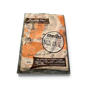 May include: A rectangular plastic tablecloth in a clear package, measuring 132 cm by 178 cm. The cloth features an orange and white graphic print of outdoor scenes, with text including Fun-n-Food Table Cloth and May Klein Inc. Ferndale 20, Michigan.