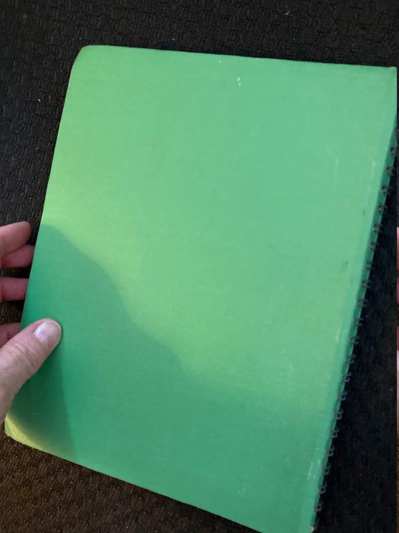 May include: A green spiral bound notebook with a plain cover.