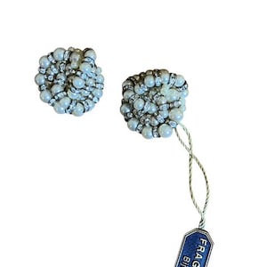 Puede incluir: Dos pendientes redondos con cuentas de aspecto perlado y detalles de pedrer&iacute;a. Los pendientes tienen un dise&ntilde;o agrupado. Una etiqueta azul con el texto "FRAGATI Bijoux" est&aacute; sujeta a uno de los pendientes.