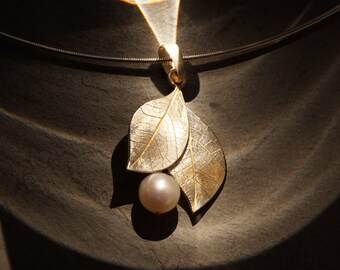 fine jewelry pendant made of silver leaves with floral structures gilded and a real white freshwater pearl