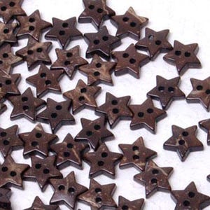 Könnte beinhalten: Eine Sammlung kleiner, sternförmiger Knöpfe mit einem dunkelbraunen, gesprenkelten Muster. Jeder Knopf hat ein fünfzackiges Design mit zwei Löchern in der Mitte zur Befestigung. Die Knöpfe sind lose über den gesamten Bildbereich verteilt angeordnet.