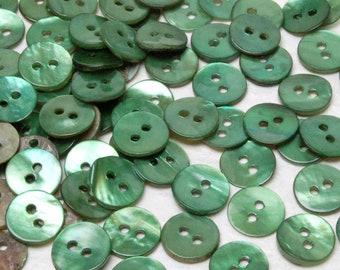 May include: A large group of green iridescent buttons with two holes each. The buttons are made of a pearlescent material and have a slightly textured surface.