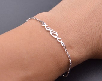 May include: A silver chain bracelet with a delicate 'XOXO' charm.
