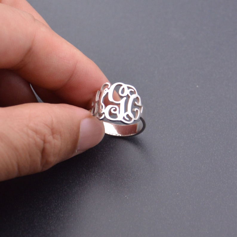 Peut inclure: Une bague en argent avec un motif de monogramme. La bague est en argent sterling et pr&eacute;sente un motif de monogramme classique.