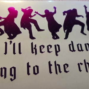 May include: A vinyl decal featuring five silhouettes of people dancing in various poses with a magenta to dark purple gradient finish. Below the figures, the text "So I'll keep dancing along to the rhythm" is printed in a bold, dark purple gothic-style font.