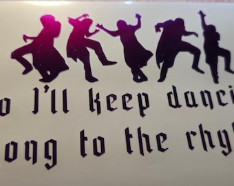 Può includere: Un adesivo in vinile con cinque sagome di persone che ballano in varie pose con una finitura sfumata dal magenta al viola scuro. Sotto le figure, il testo "So I'll keep dancing along to the rhythm" è stampato in un carattere gotico viola scuro in grassetto.