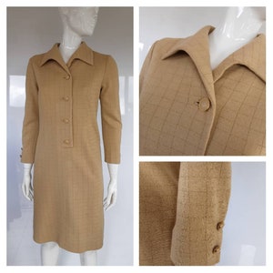 May include: A tan checkered dress with a collared neckline and long sleeves. The dress has a button closure and gold buttons.