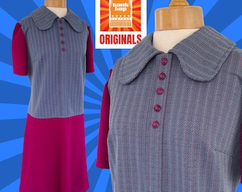 May include: A vintage dress with a blue and white striped bodice and a solid magenta skirt. The dress has a Peter Pan collar and button closures. The dress is on a mannequin.