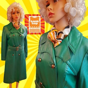 May include: A green leather trench coat with a double breasted closure, a belt, and gold buttons. The coat is on a mannequin wearing a scarf.