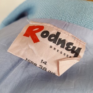 May include: A light blue dress with a pink label that says "Rodney Dresses" and "Hips 38 in 14".