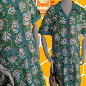 May include: Green vintage button-down shirt with a geometric pattern in white, orange, and green. The shirt has short sleeves, a collar, and two front pockets. The Tank Top Vintage logo is visible in the background.