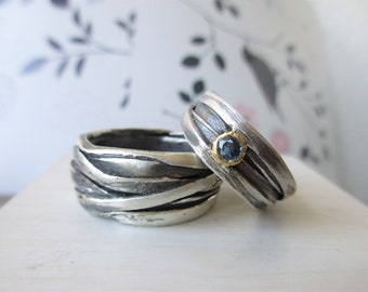 May include: Two silver rings with a textured, woven design. One ring features a blue gemstone set in gold.