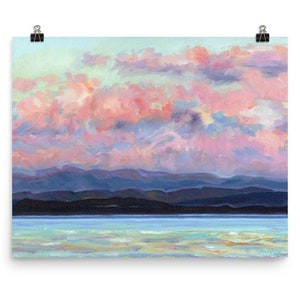 May include: A painting of a pink and blue sunset over a dark blue mountain range and a body of water. The sky is filled with fluffy clouds.