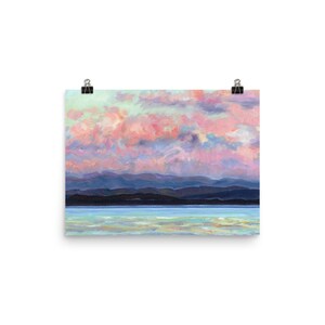 May include: A painting of a pink and purple sunset over a dark blue mountain range and a light blue body of water.