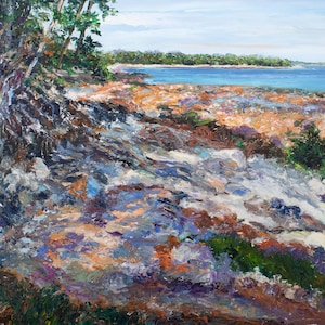 May include: An impressionistic landscape painting depicting a shoreline with a vibrant palette. The artwork features a rocky foreground with shades of gray, purple, and orange, leading to a sandy beach and a blue body of water. Trees frame the scene.
