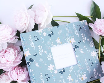 May include: A light blue scrapbook with a floral and butterfly pattern. The cover has a white window with the text "The Golden Years" and "Our Journey Together".