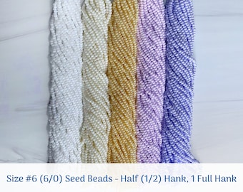 Könnte beinhalten: Vier Spulen mit Größe 6/0 Perlen. Die Spulen sind weiß, cremefarben, helllila und lavendelfarben. Der Text auf dem Bild lautet "Size #6 (6/0) Seed Beads - Half (1/2) Hank, 1 Full Hank".