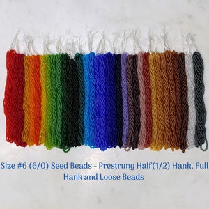 May include: A variety of colors of size 6/0 seed beads, prestrung in half hanks, full hanks, and loose beads.  The beads are arranged in rows, with each row a different color.  The colors include red, orange, yellow, green, blue, purple, brown, gold, silver, and white.  Size #6 (6/0) Seed Beads - Prestrung Half (1/2) Hank, Full Hank and Loose Beads