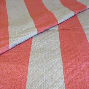 May include: A striped quilt with alternating red and gray stripes. The quilt is made of a soft, textured fabric.