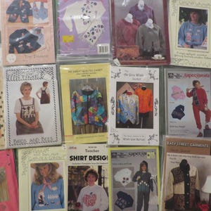 May include: A selection of vintage sewing pattern books, showcasing diverse clothing designs. The covers feature images of completed garments, including jackets, shirts, and dresses, with text such as "Birds and Bees" and "Doll Shirt".