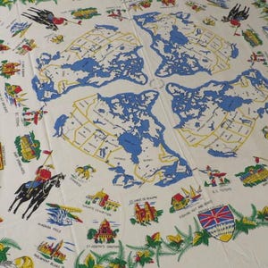 May include: A white square scarf featuring a repeating blue and yellow map of Canada. The border is decorated with green maple leaves, colourful provincial coats of arms, illustrations of landmarks, and figures of mounted police officers.
