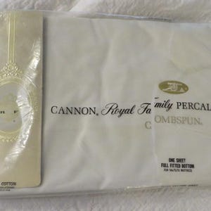 May include: A white Cannon Royal Family percale fitted sheet in original plastic packaging. The label reads All Cotton, Cannon Royal Family Percale Combed Spun, and One Sheet Full Fitted Bottom for 137x190 cm mattress. A gold oval logo is visible.