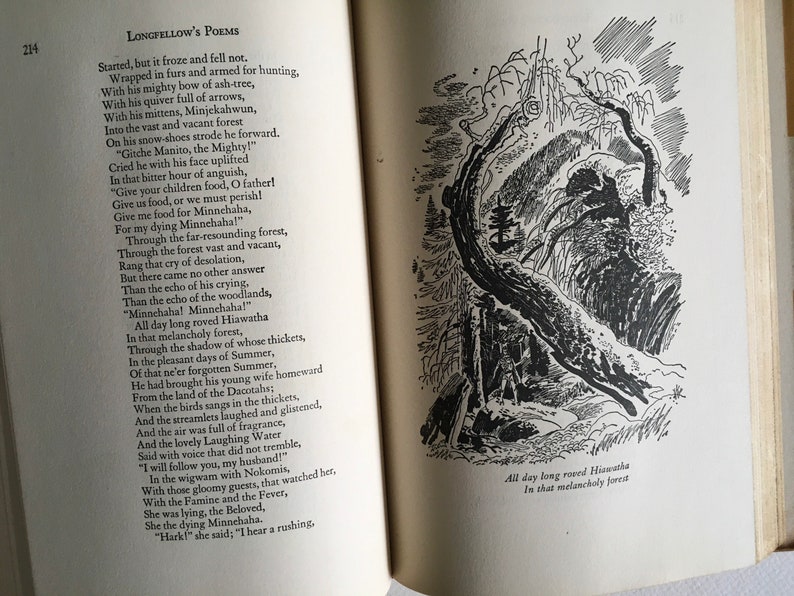 May include: A black and white illustration of a forest scene with a large tree trunk in the foreground. The text "All day long roved Hiawatha In that melancholy forest" is printed below the illustration.