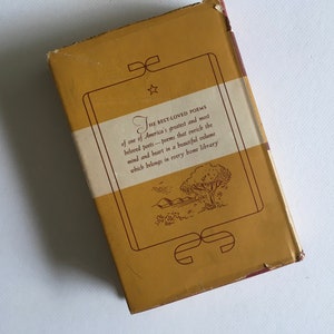 May include: The back cover of a yellow book with a brown border and a white label. The label has the text "THE BEST-LOVED POEMS of one of America's greatest and most beloved poets - poems that enrich the mind and heart in a beautiful volume which belongs in every home library." There is a small star above the word "THE" and a decorative design at the bottom of the label.