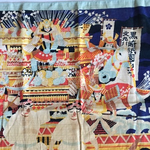 May include: A colourful Japanese textile depicting a scene of samurai warriors on horseback. The textile is blue, white, red, yellow and black. The text on the textile reads "Black Horse Regiment".