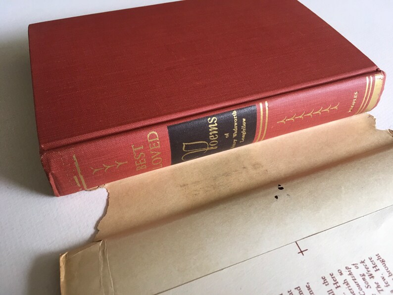 May include: A red hardcover book titled "Best Loved Poems of Henry Wadsworth Longfellow". The book is open and the spine is visible.