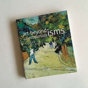 May include: A book titled "art beyond isms" with a painting of a path through a forest on the cover. The text on the cover reads "Masterworks from El Greco to Picasso in the Phillips Collection."