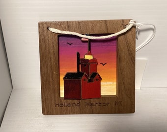 Adorno de faro holandés pintado a mano en madera de nogal con cielo vespertino, de aproximadamente 3 1/2 pulgadas. Está ubicado en el lago Michigan, en Holland, Michigan.