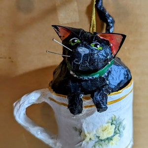 Adorno de gato mache de papel hecho a mano, gatito negro en una taza de té